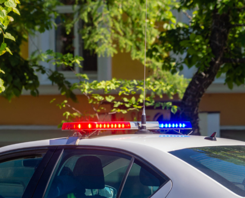 Mobile patrol car with lights on during the day