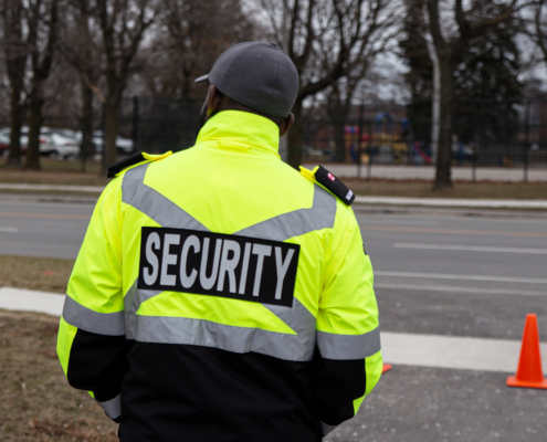 Security guard standing outside in school parking lot