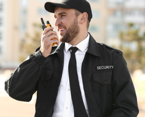 Male security guard with portable radio transmitter outdoors